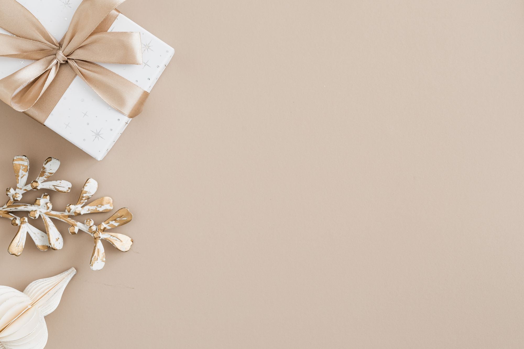 Neutral verpacktes Geschenk auf beigefarbenem Hintergrund